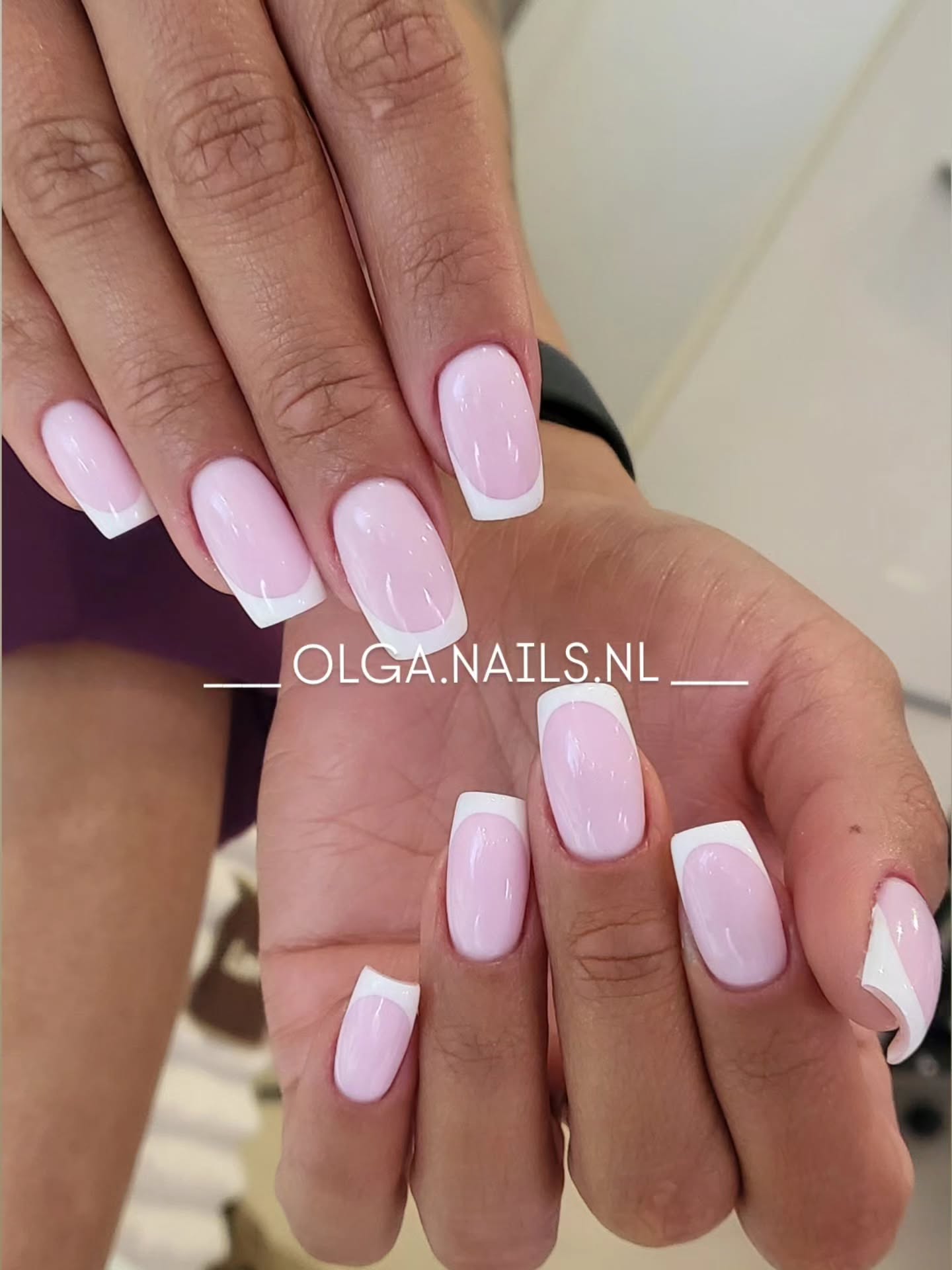 Roze French manicure met witte tips, twee handen boven elkaar